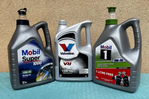 Trzy butelki oleju silnikowego: Mobil Super 1000, Valvoline VR1 i Mobil 1.