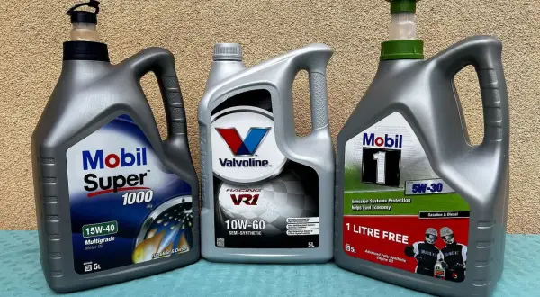 Trzy butelki oleju silnikowego: Mobil Super 1000, Valvoline VR1 i Mobil 1.